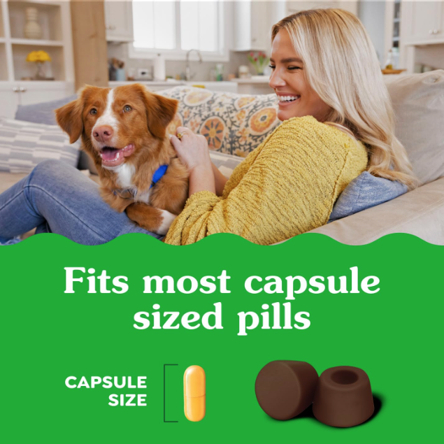 A woman and her dog sit on a couch in a bright living room, with a green text banner at the bottom reading 'Fits most capsule sized pills' and showing a yellow capsule and two brown cone-shaped inserts.